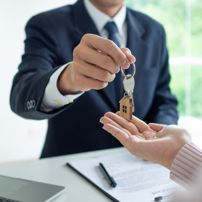 The employee gave the house keys to the customer for mortgage or purchase. Real Estate Agents and Clients Discussing Mortgage Contracts